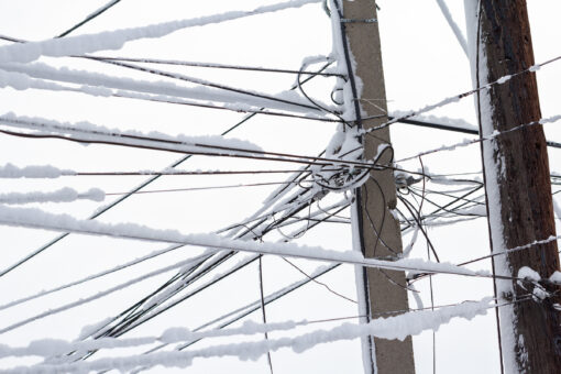 Electricity poles and wires under snow